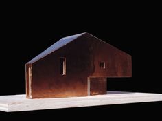 a metal house sitting on top of a white table