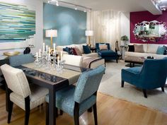 a living room filled with lots of furniture and a dining table surrounded by blue chairs