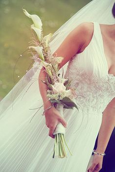 a woman in a wedding dress holding a bouquet