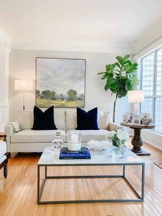 a living room filled with furniture and a large painting on the wall above the couch