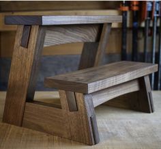 a wooden bench sitting on top of a hard wood floor