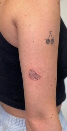 a woman with a tattoo on her arm has a piece of fruit in the shape of a heart