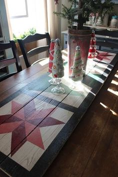 a wooden table topped with christmas trees and vases filled with candy canes on top of it