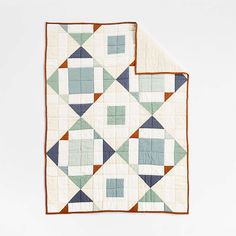 two quilts on top of each other in different colors and shapes, one with an orange border