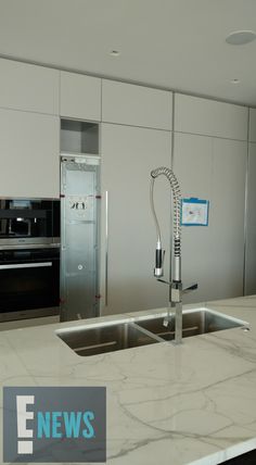 a kitchen with marble counter tops and stainless steel appliances in the backround area