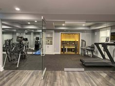 a gym with mirrors and treadmills in it