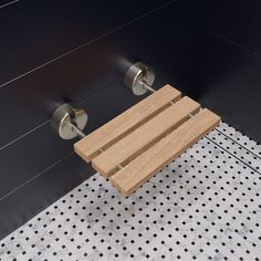 a wooden bench sitting on top of a tile floor next to a shower head and toilet paper dispenser