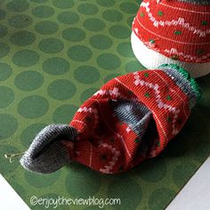 two knitted shoes sitting on top of a green surface