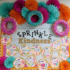 a bulletin board with doughnuts and paper flowers on it that says sprinkle kindness