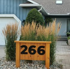 a house with a number sign in front of it and some plants on the side