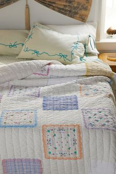 a bed with a quilt and pillows on it