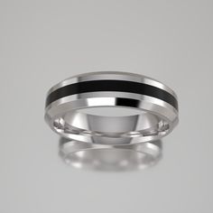 a wedding band with black and silver inlays on the inside, set against a gray background