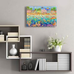 a painting is hanging on the wall next to bookshelves and vases with flowers