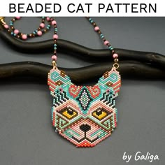 the beaded cat necklace is hanging on a branch