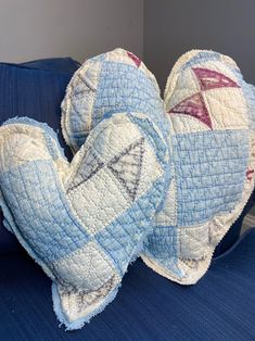 two heart shaped pillows sitting on top of a blue couch