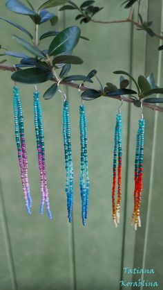 four different colored beads hanging from a tree branch