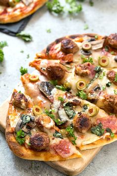 two pizzas with different toppings sitting on top of a cutting board next to each other