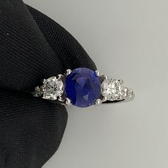 This 14kt. White Gold Custom Designed Ring was created by our master setters and designers. This ring contains an Oval Mixed Cut Stunning Natural Ceylon Blue Sapphire with NO Indications of heat. It weighs 1.67 carats and is Vivid Deep Blue in Color with light imperfections. It is surround by 16 Round Brilliant Natural Diamonds weighing .78 carats total weight and the stones are graded G in Color and VS2 in a clarity. The band width is 1.85mm and US Ring size 5 3/4. This ring can be sized. Blue Oval Solitaire Diamond Ring, Gia Certified Sapphire Ring, Timeless Blue Ring With Center Stone, Timeless Blue Rings With Center Stone, Timeless Blue Sapphire Ring Gia Certified, Classic Sapphire Rings With Vvs Clarity, Gia Certified Sapphire Ring With Round Cut, Blue Diamond Solitaire Ring, Sapphire Rings With Vvs Clarity And Round Cut