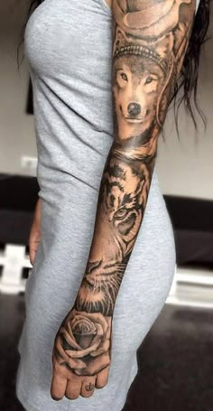 a woman with a wolf tattoo on her arm and hand is holding a rose in front of her body