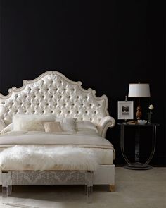 a white bed sitting next to a black wall