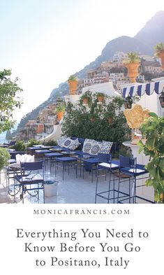 an outdoor dining area with blue and white furniture, overlooking the ocean in positano