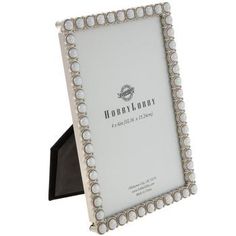 a white and black photo frame with pearls on the edges, in front of a white background