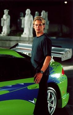 a man standing next to a green sports car