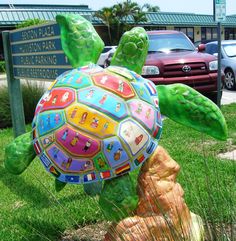 a colorful turtle statue sitting in the grass