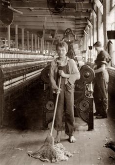 an old black and white photo of a boy cleaning the floor with a broom in front of him