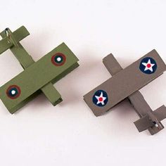 two toy airplanes sitting next to each other on top of a white surface with red and blue stars