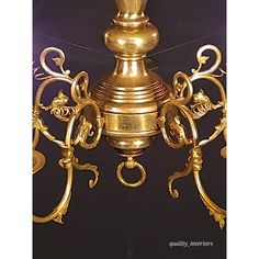 an ornate gold candle holder is shown against a black background, with the top part of it's light turned on