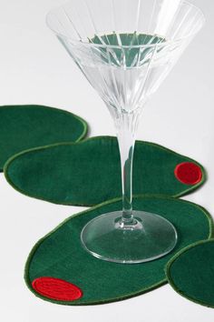 three wine glasses sitting on top of green coasters