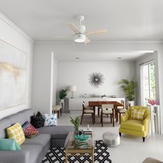 a living room filled with furniture and a ceiling fan in the middle of the room