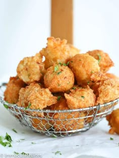 a basket filled with fried fish on top of a white table next to an orange and pink sign