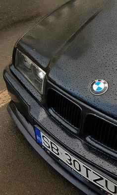 a black bmw is parked on the street