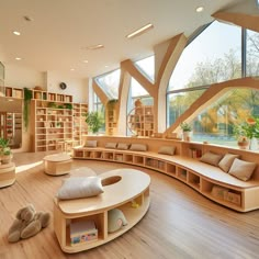 a room with bookshelves, couches and stuffed animals on the wooden floor