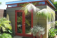 a small garden shed with two plants in it