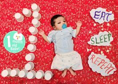 a baby is laying on the floor with his pacifier in his mouth and surrounded by magnets