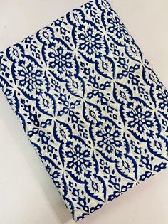 a blue and white tile with an intricate design on the bottom half, sitting on a table