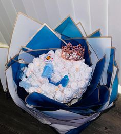 a blue and white bouquet with a tiara on top, surrounded by other items