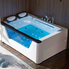 a large white bath tub sitting on top of a wooden floor