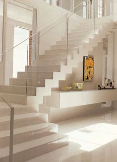 there is a white staircase in the house that has been decorated with art and decorations