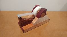 a piece of wood with a tape dispenser on it sitting on a table