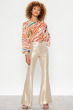 A Faux Leather Pant featuring bell bottom with front zip closure. Seamed Metallic Gold S (4-6) M (6-8) L (8-10) 91% Polyester 9% Spandex First Day Of School Fits, Metallic Pants, Seasonal Color Analysis, Metal Clothing, Leather Pant, Unique Boutique, Fashion Week Runway, Buy Gold, Faux Leather Pants