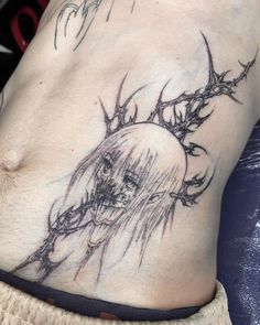 a woman's stomach with an artistic tattoo design on her side and the image of a deer