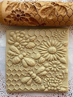 a piece of carved wood sitting on top of a doily next to a rolling pin