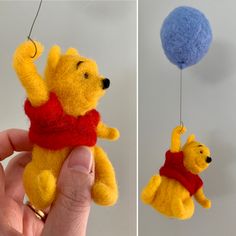 a hand holding a small stuffed toy in the shape of a winnie the pooh hanging from a string