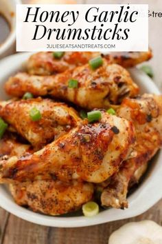 honey garlic drumsticks in a white bowl with green onions