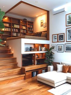 a living room filled with furniture and bookshelves next to a staircase leading up to a loft bed