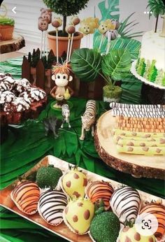 an assortment of desserts on display at a jungle birthday party